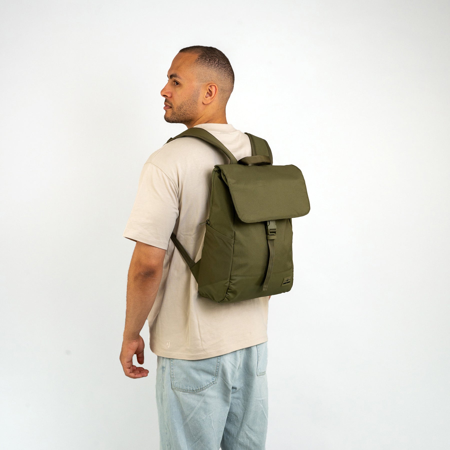 Mann trägt olivgrünen Johnny Urban Rucksack 'Mika' mit Klappe und Verschluss auf dem Rücken
