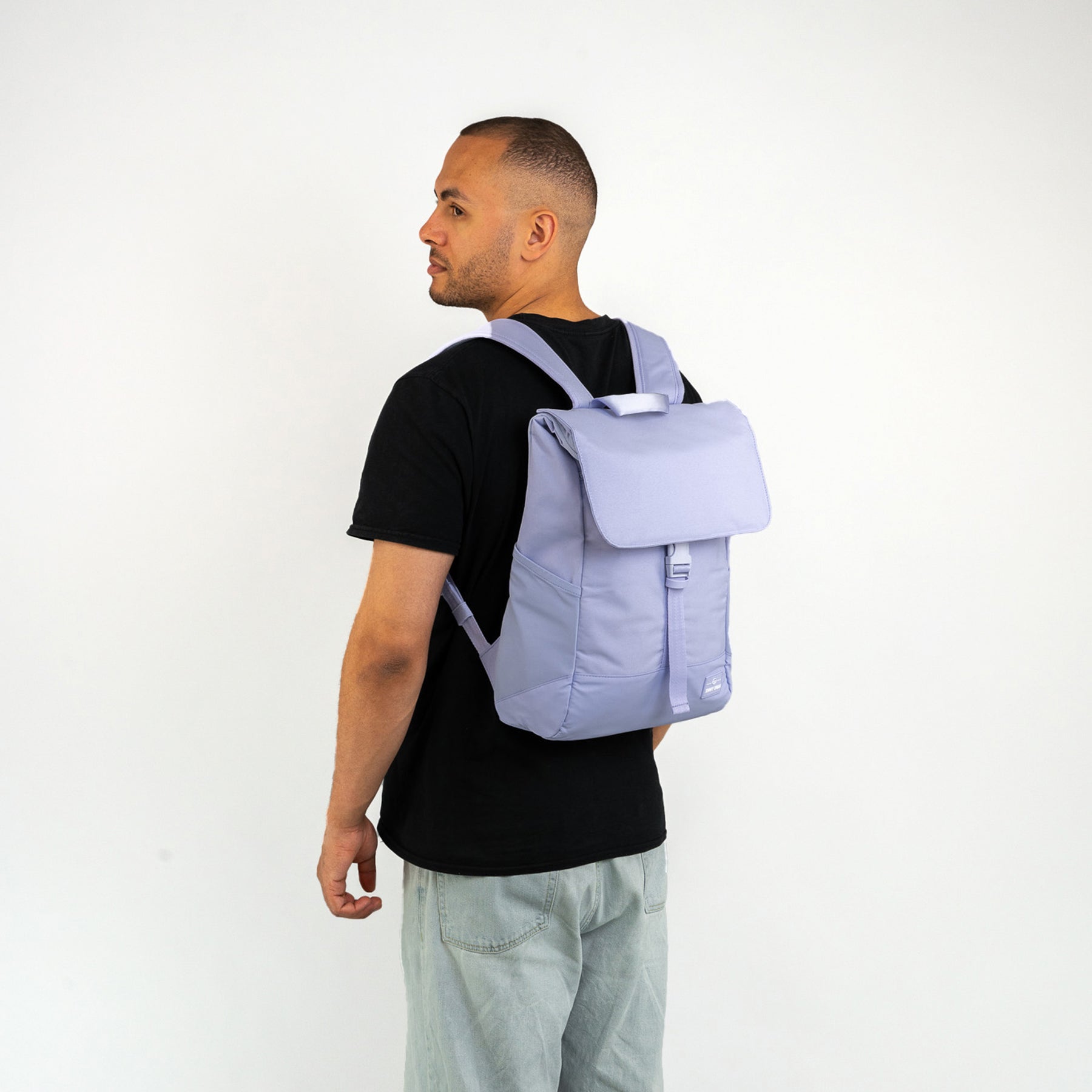 Mann trägt lila Johnny Urban Rucksack 'Mika' mit Klappe und Schnalle