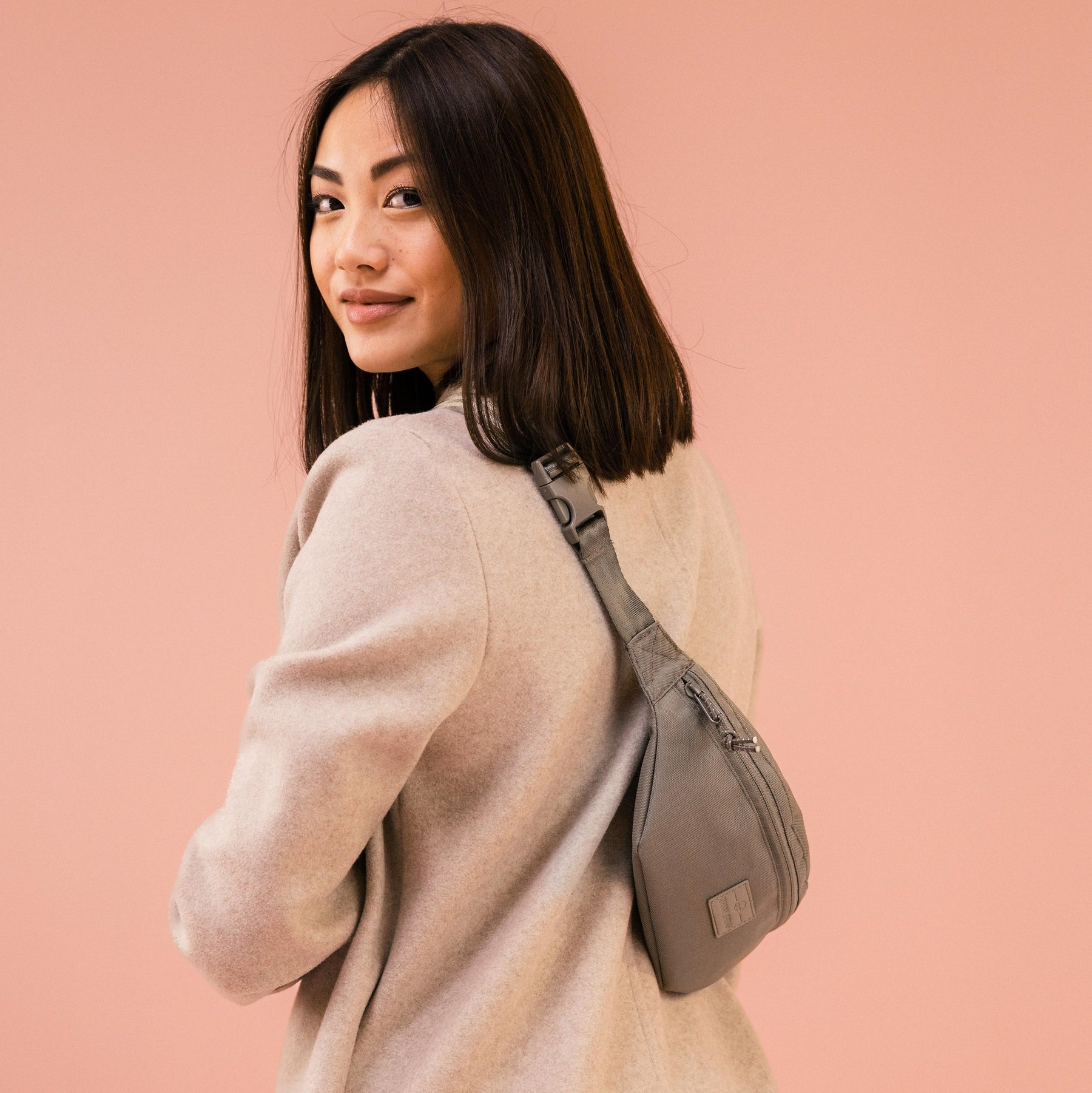 Frau trägt Johnny Urban Bauchtasche 'Erik Small' in desert grey über den Rücken