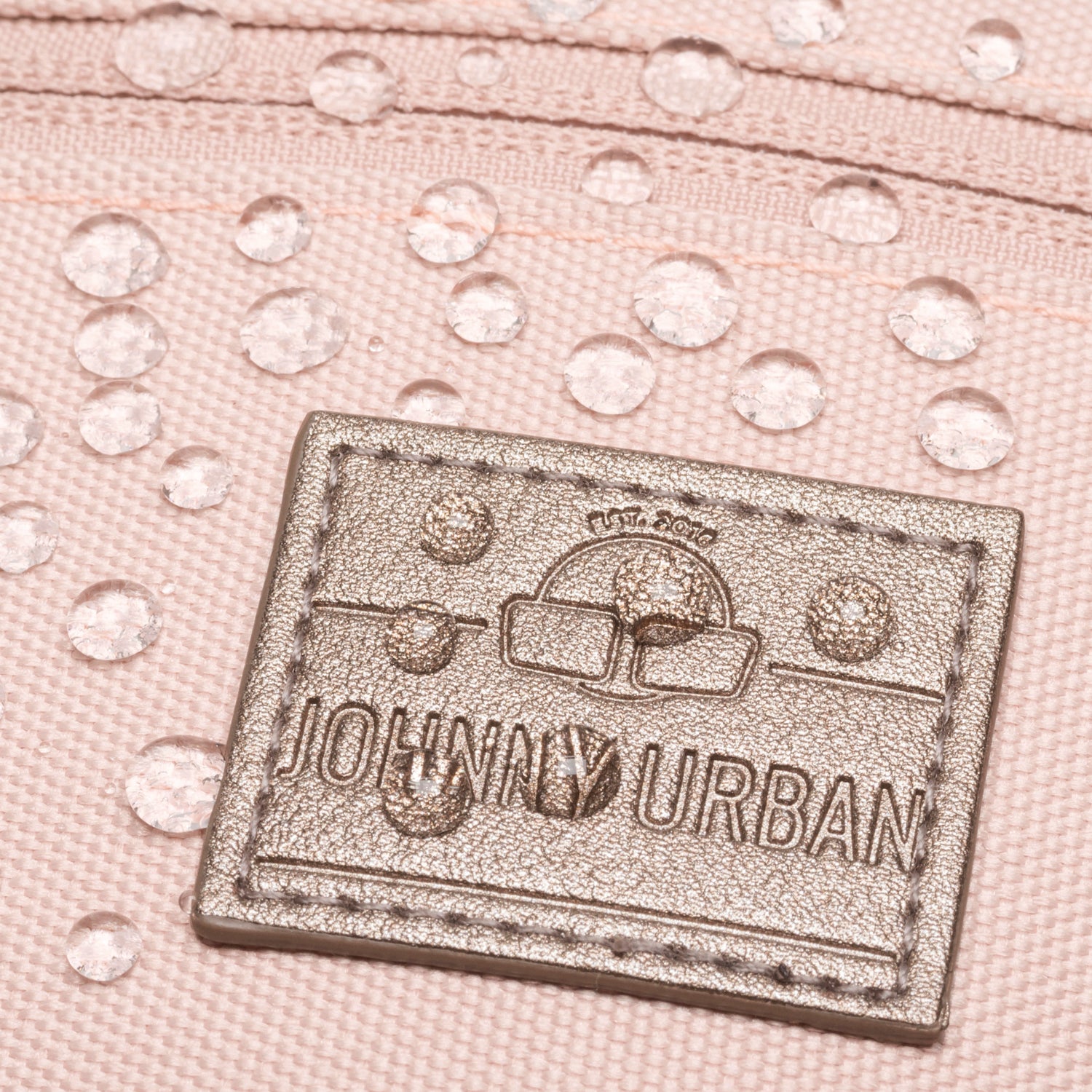 Nahaufnahme der wasserabweisenden rosa Bauchtasche 'Ben' mit Johnny Urban Logo und Wasserperlen