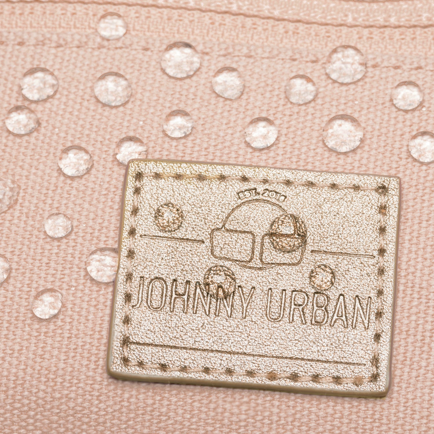 Nahaufnahme des wasserabweisenden Canvas-Gewebes und des aufgenähten JOHNNY URBAN Lederlabels der rosa Bauchtasche 'Toni'