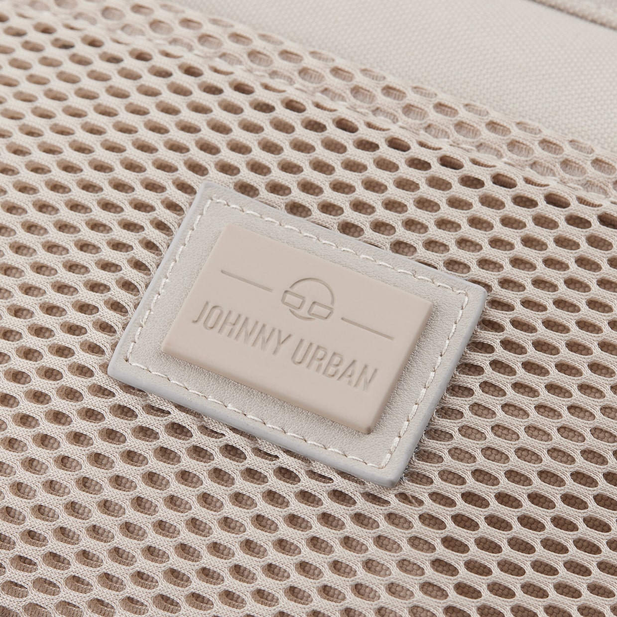 Beiges, rechteckiges Logo-Label mit Prägung 'Johnny Urban' auf Netzstoff der Umhängetasche 'Elliot'