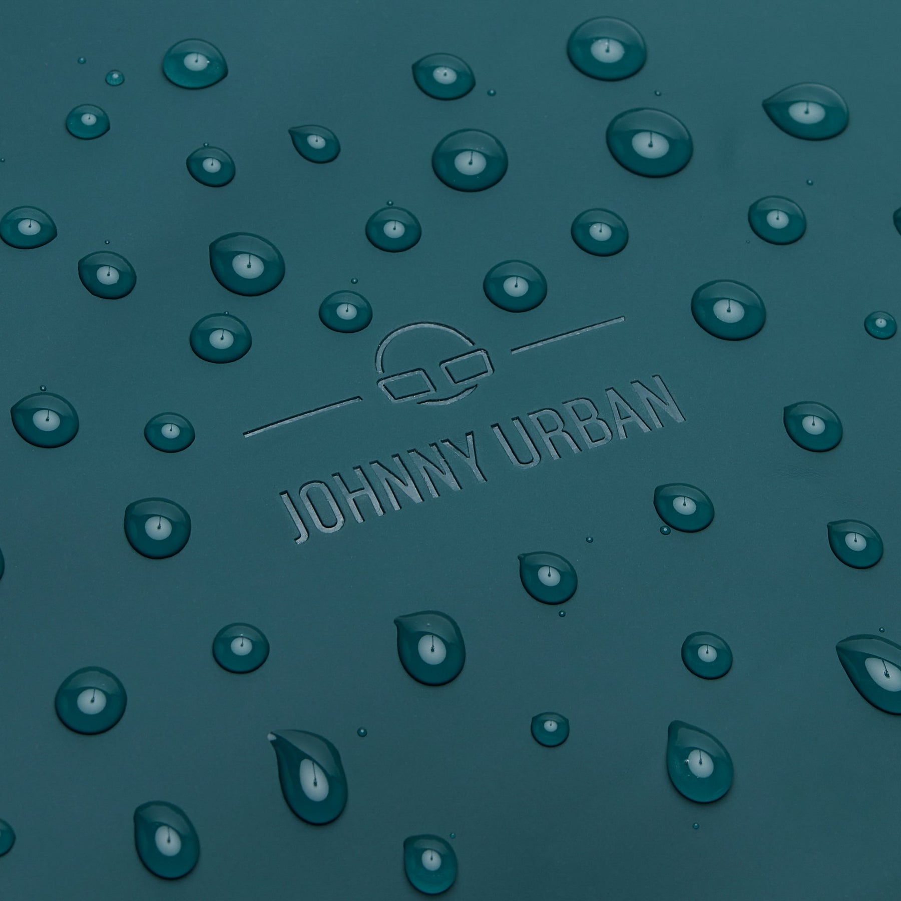 Wasserabweisendes Material des Rucksacks 'Hailey' in Petrolgrün mit Wasserperlen und eingeprägtem Johnny Urban Logo