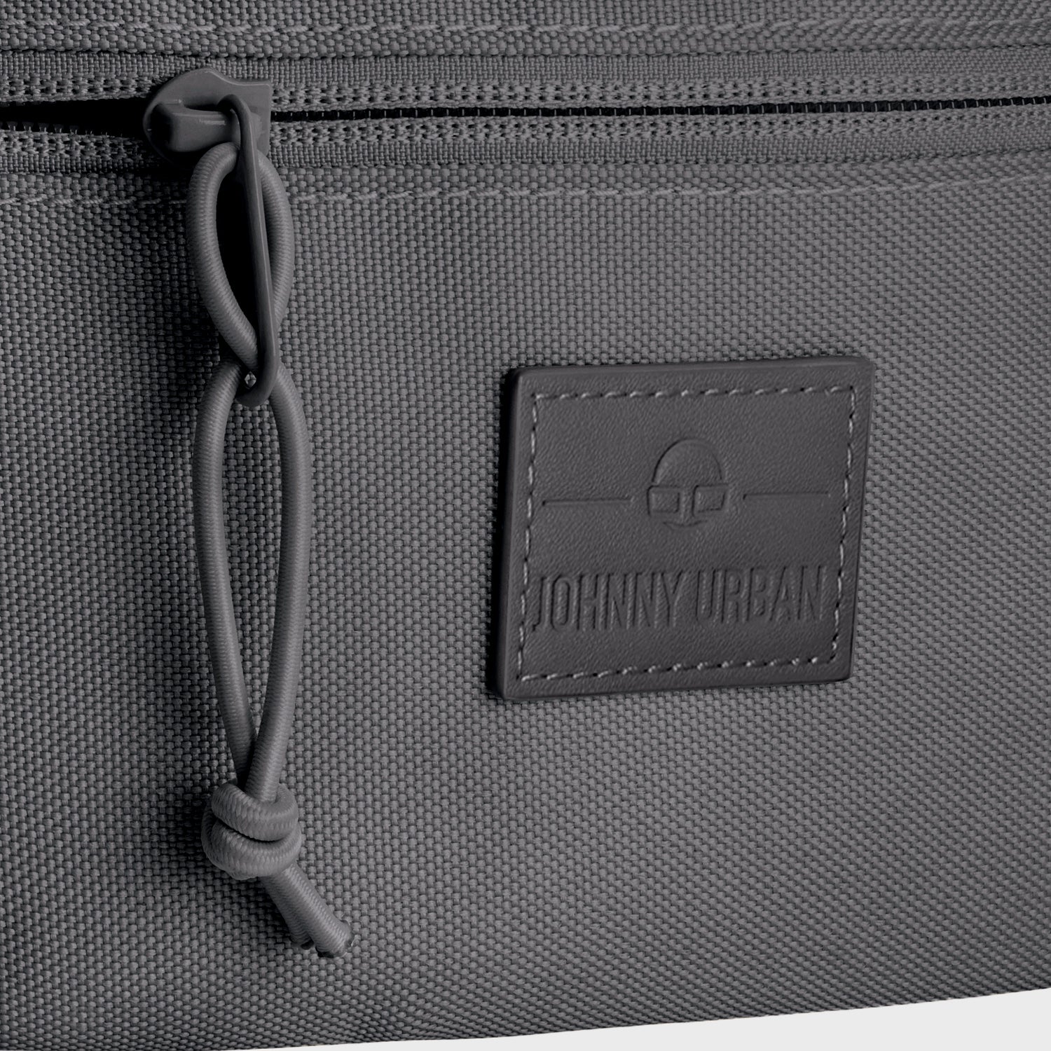 Gepäckdetail der Bauchtasche 'Erik Small' von Johnny Urban mit Reißverschluss und Logo-Patch.