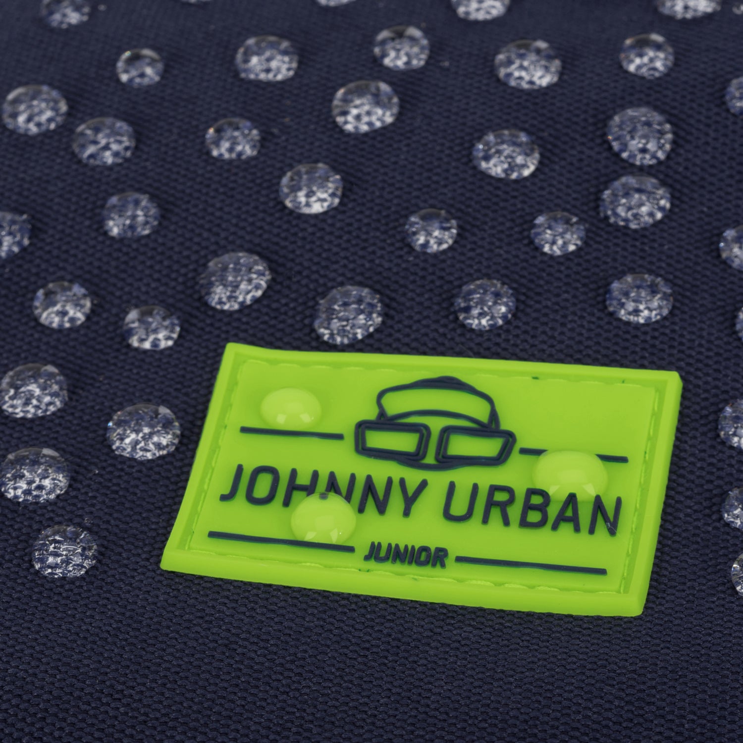 Wasserdichter dunkelblauer Kinderrucksack mit reflektierenden Punkten und grünem Johnny Urban Junior Logo