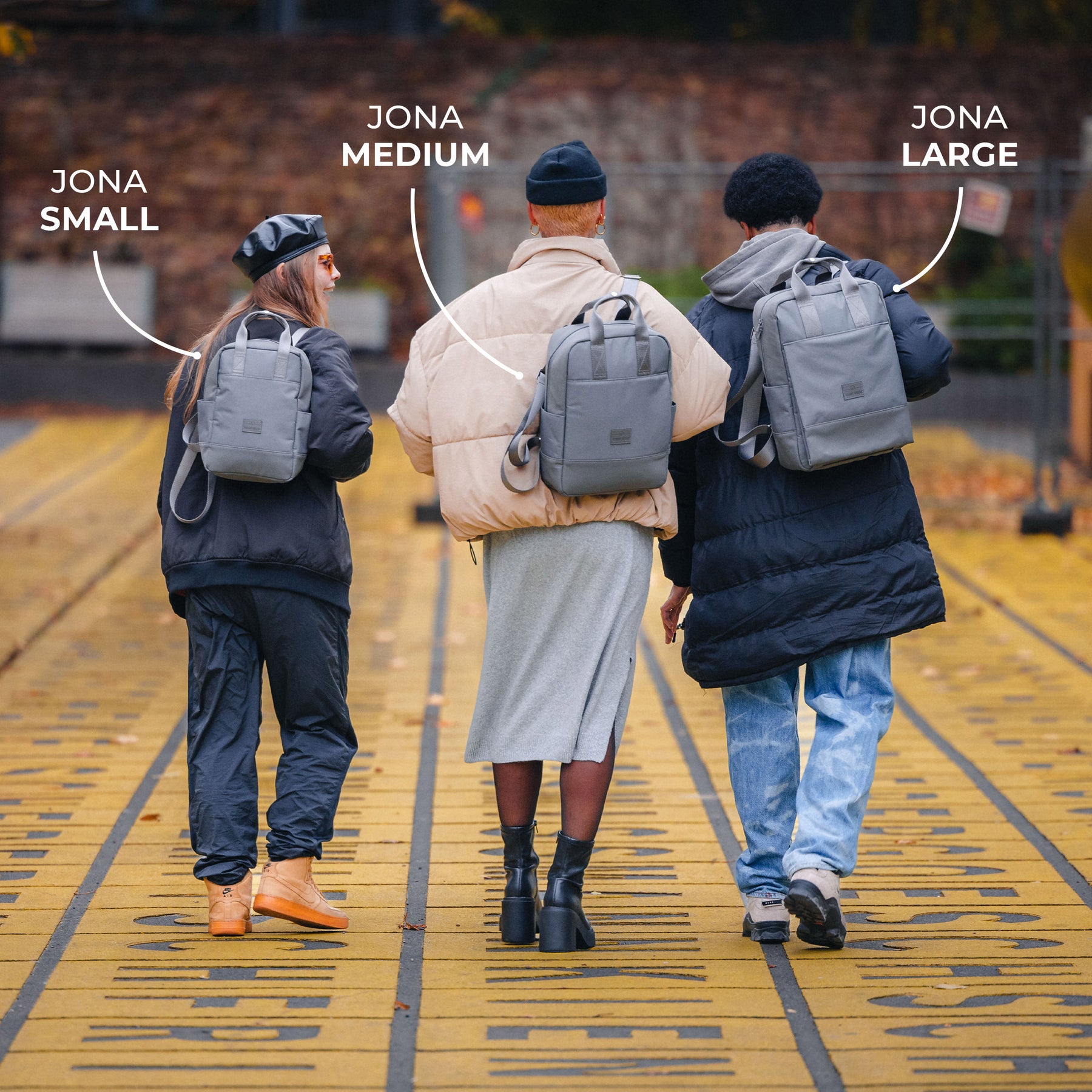 Drei Personen von hinten mit grauen Johnny Urban Jona Rucksäcken in den Größen Small, Medium und Large