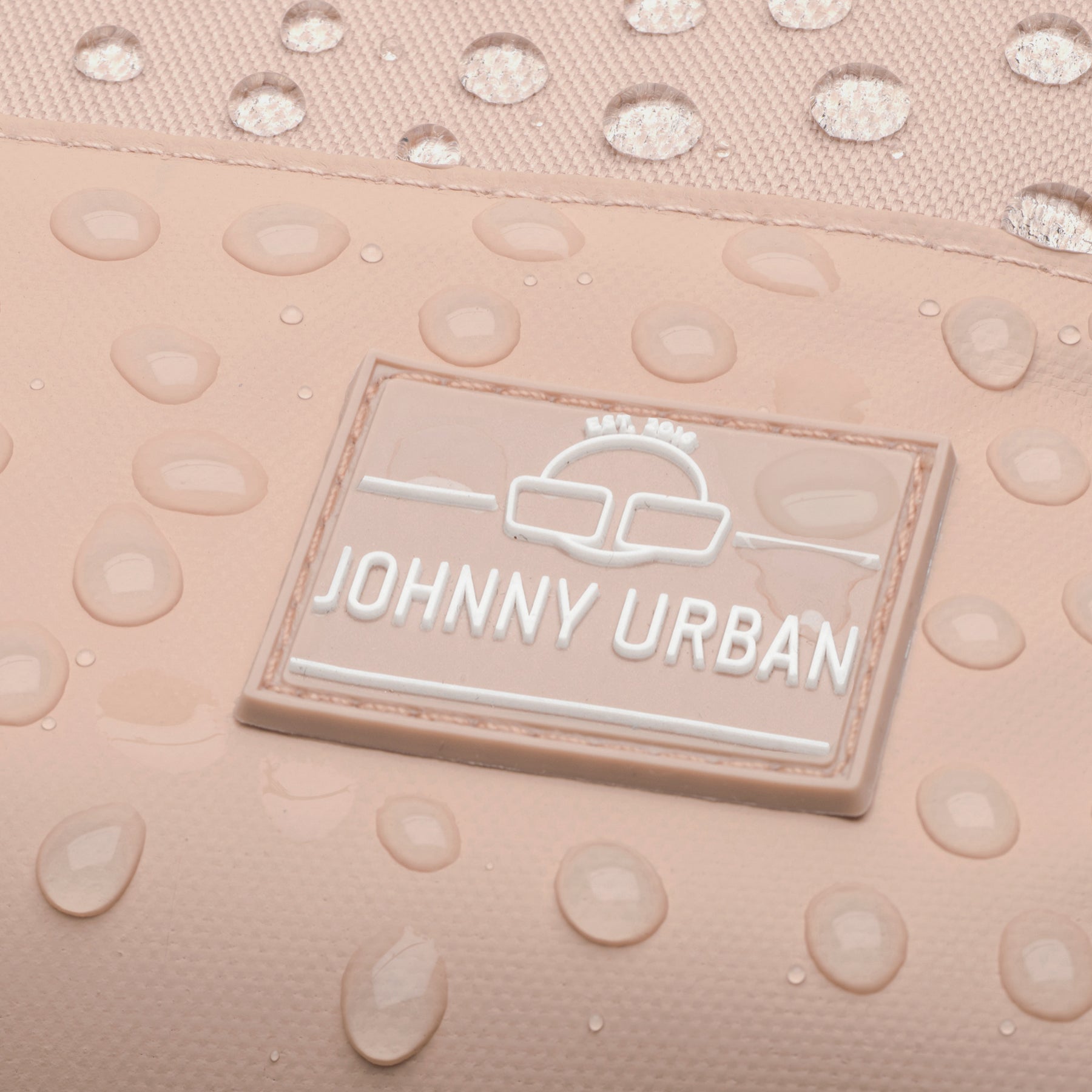 Nahaufnahme des wasserabweisenden Materials und Markenlabels des Johnny Urban Rucksacks Mika in rosa