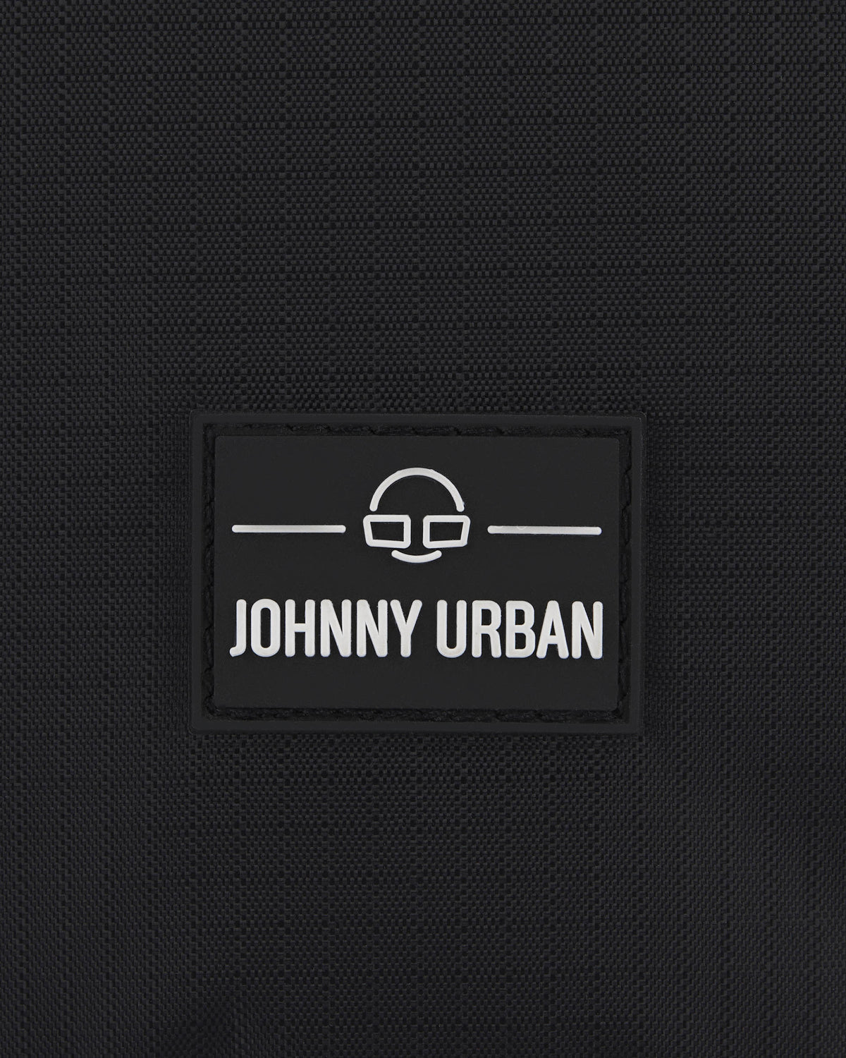 Nahaufnahme des Johnny Urban Logos auf schwarzem Stoff einer Kulturtasche
