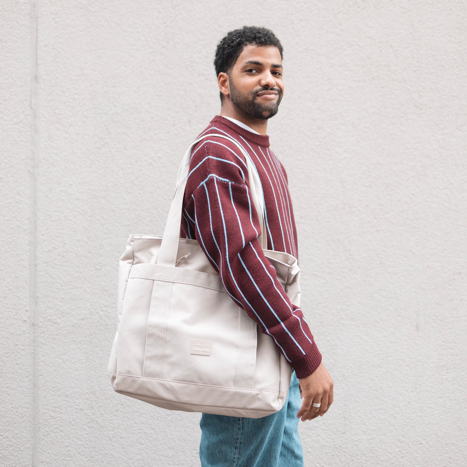 Unser männliches Model präsentiert sich hier mit der Johnny Urban Shopperbag "Kim" in beige.