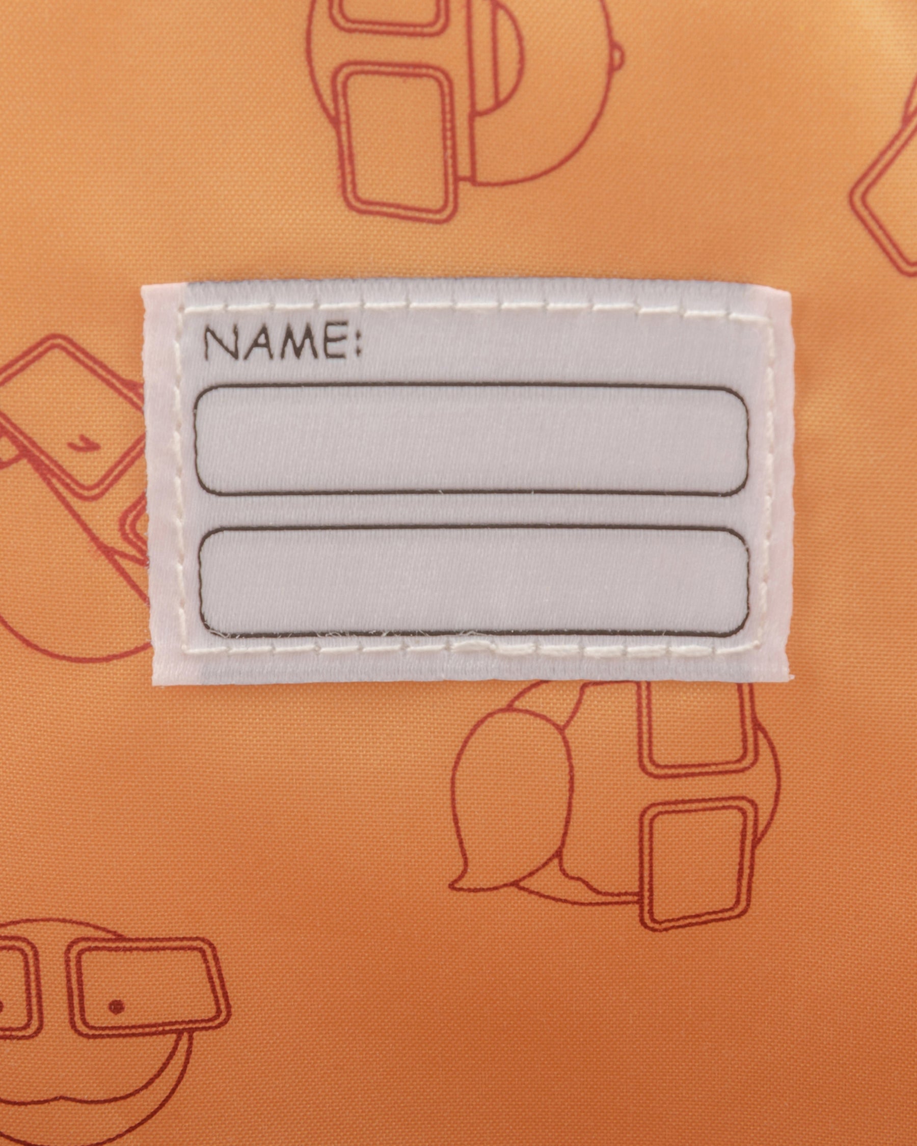 Namensschild mit zwei leeren Feldern auf orangem Kinderrucksack "Linus" mit Muster aus Comicgesichtern
