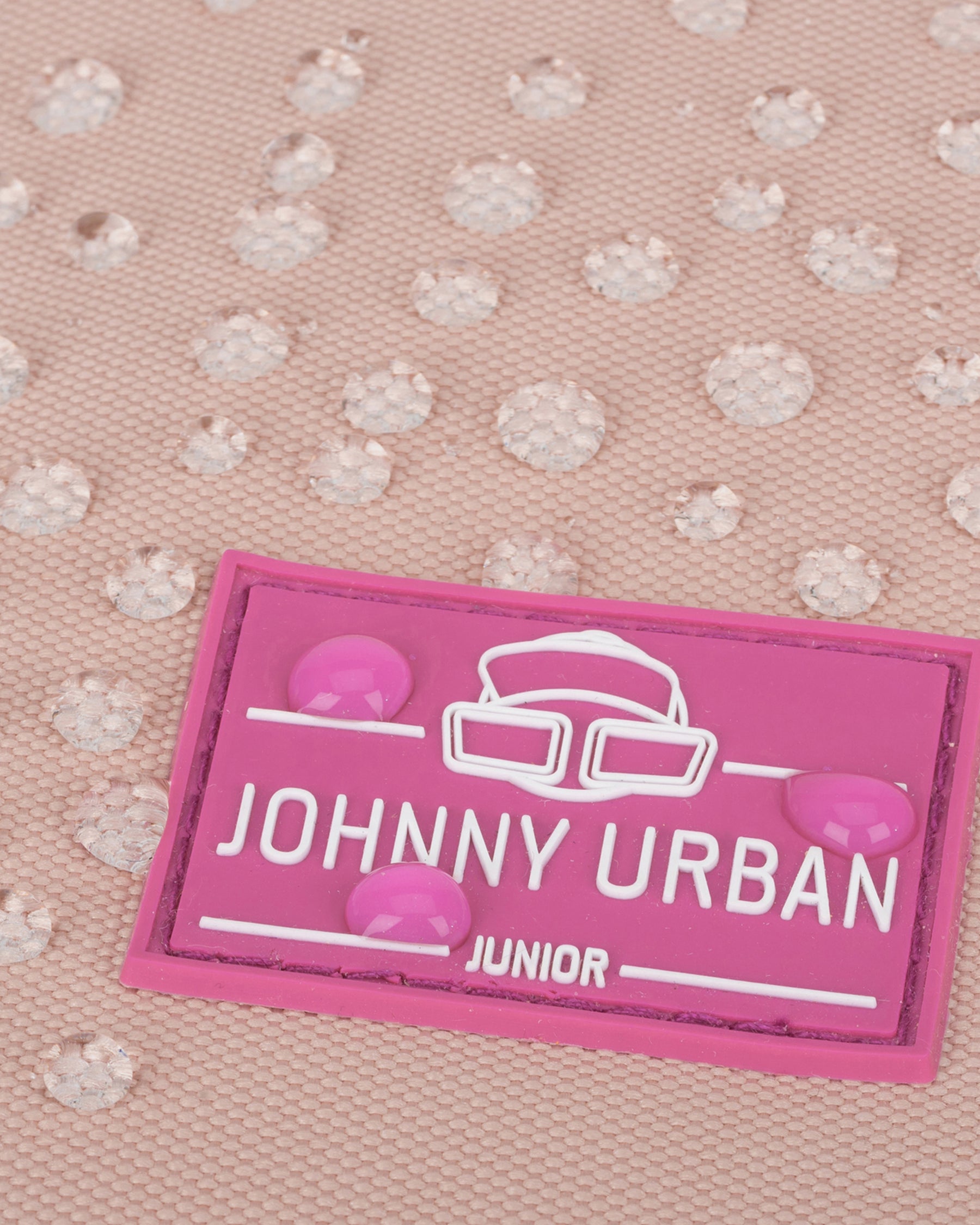 Nahaufnahme des wasserabweisenden Stoffs des Kinderrucksacks 'Linus' mit pinkem Johnny Urban Junior-Logo