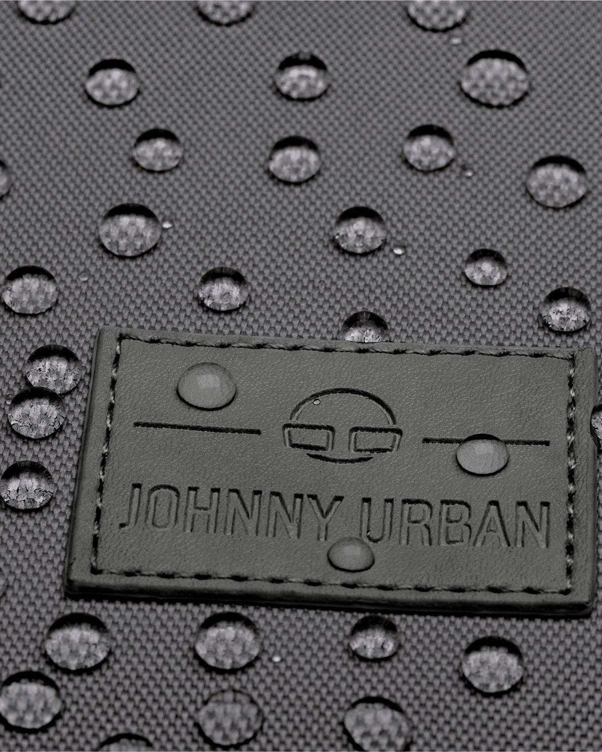 Nahaufnahme des wasserdichten Materials und Johnny Urban Logo auf grauem Rolltop Rucksack Robin Small