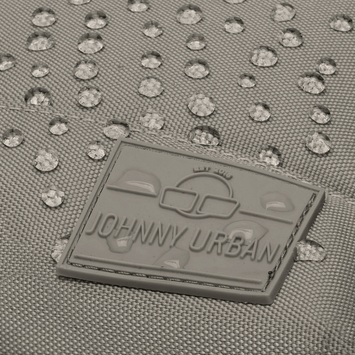 Nahe Aufnahme des wasserabweisenden Materials und des grauen Johnny Urban Logos am Damenrucksack 'Mia'