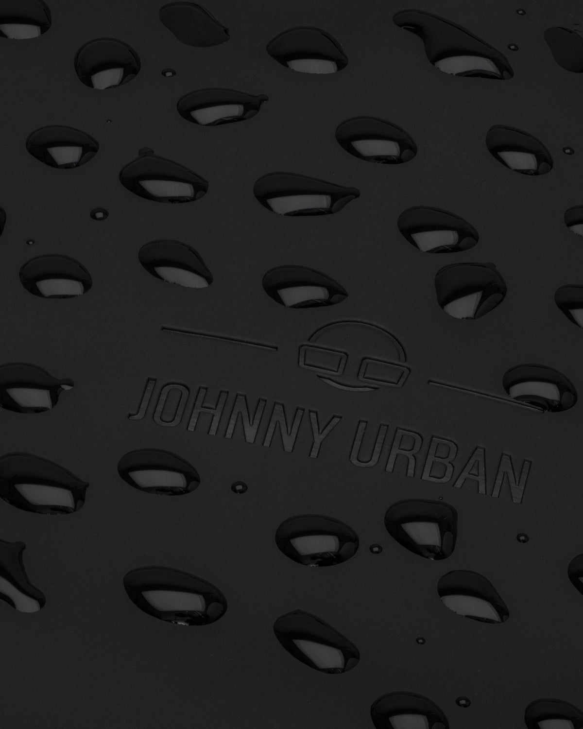 Prägung des Johnny Urban Logos auf dem schwarzen Rolltop Rucksack 'Henry'