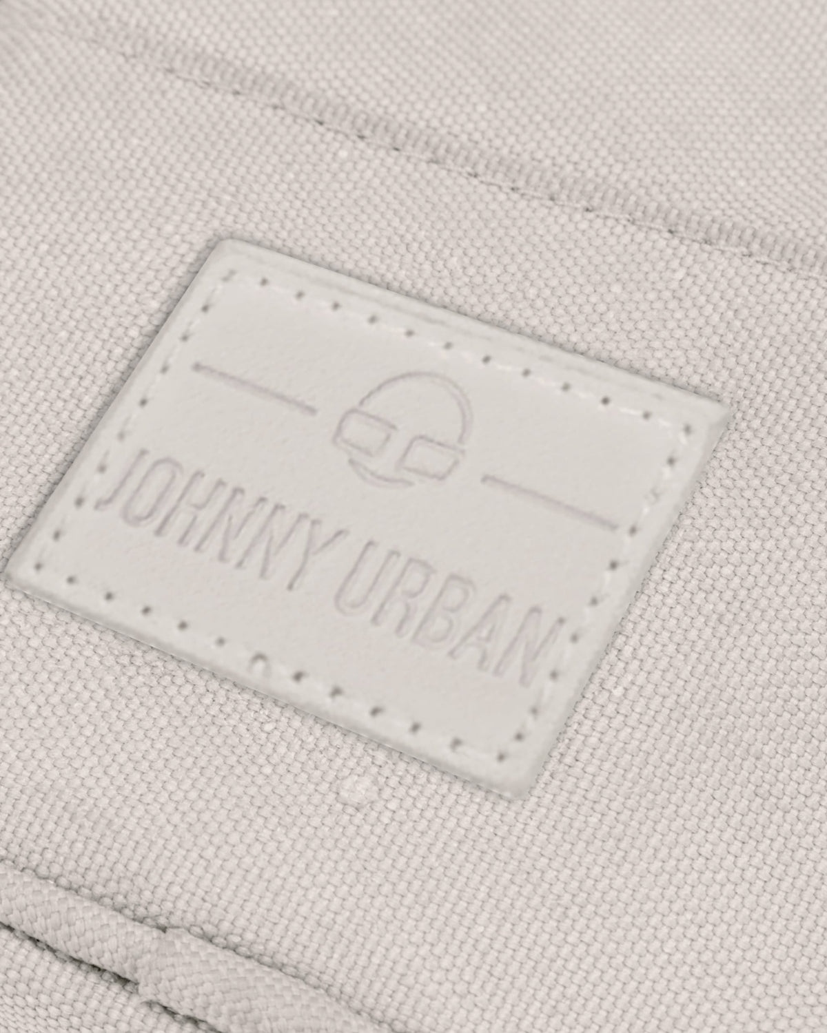 Nahe Aufnahme des Johnny Urban Logos auf der sandfarbenen Umhängetasche 'Josh'